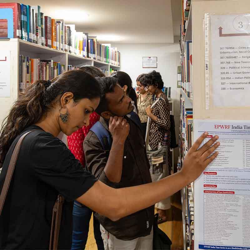 Readers browsing policy and research materials in a library
