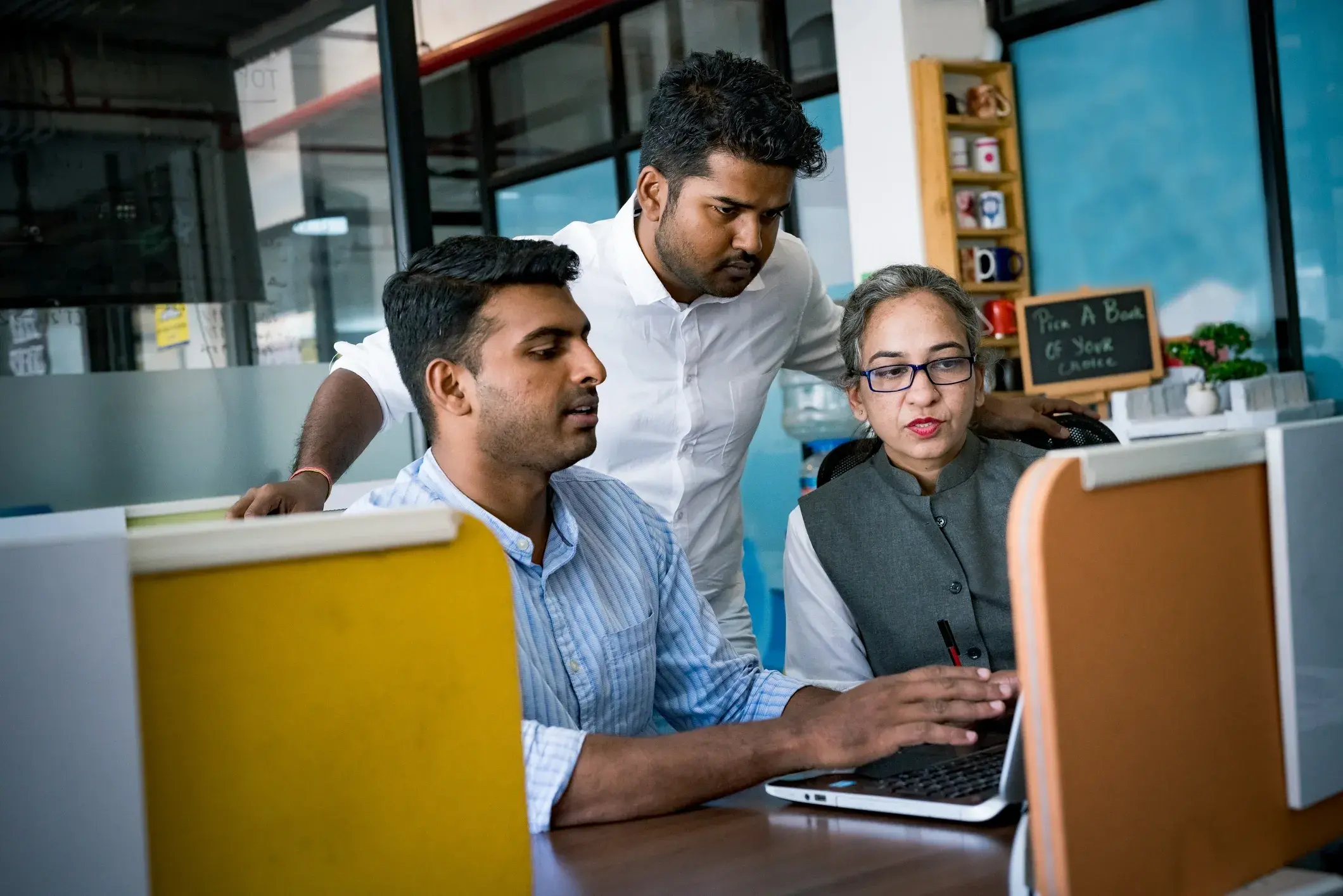 Professionals collaborating around a laptop